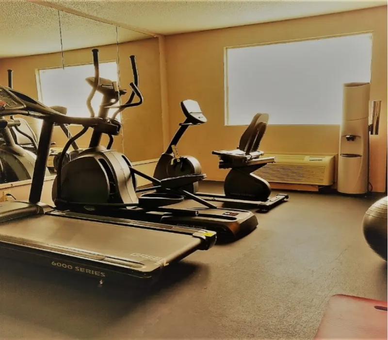 A gym with many different equipment on the floor.