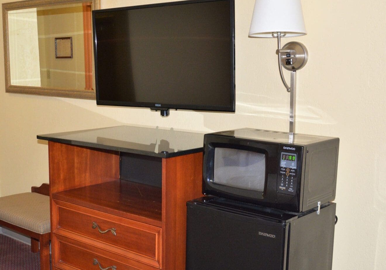 A television and microwave in a room.